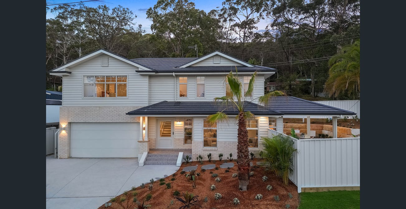 a house with a driveway and palm trees